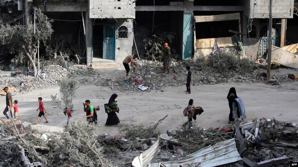 Palestinos caminan entre los escombros un día después de una operación israelí en Nuseirat, en el centro de la Franja de Gaza, el 9 de junio de 2024.