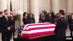 Members of the public walk past Justice Antonin Scalia’s flag-draped coffin inside the Great Hall of the US Supreme Court in Washington, February 19, 2016. (M.Snowiss/VOA)