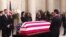 Members of the public walk past Justice Antonin Scalia’s flag-draped coffin inside the Great Hall of the US Supreme Court in Washington, February 19, 2016. (M.Snowiss/VOA)