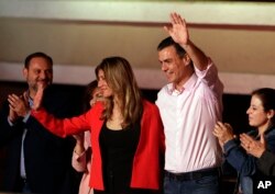 El presidente del gobierno español Pedro Sánchez y su esposa María Begonia Gómez, saludan a partidarios en la sede de su partido PSOE, mientras aguardaban los resultados de las elecciones generales, el 28 de abril de 2019.