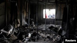 People are seen outside the Directorate of province building after it was set on fire by Kurdish protesters in Pera magroon district in Sulaimaniyah, Iraq, Dec. 19, 2017. 