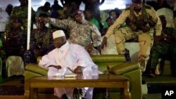 Gambian officers signal to the media not to block the public's view during President Yahya Jammeh's final rally in Banjul, Gambia, Nov. 29, 2016. Gambia's opposition parties are rallying together behind a single candidate for the first time in decades, forming a coalition they hope will oust longtime President Yahya Jammeh, who has been accused of human rights abuses throughout his 22-year rule. 