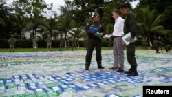 Colombia's President Juan Manuel Santos looks more than 12 tons of cocaine seized in Apartado, Colombia, Nov. 8, 2017. 