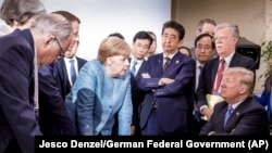 CANADA -- German Chancellor Angela Merkel speaks with U.S. President Donald Trump during the G-7 Leaders Summit in La Malbaie, Quebec, June 9, 2018