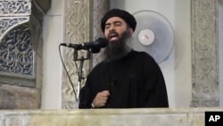 FILE - This image from video posted in July purports to show Islamic State leader Abu Bakr al-Baghdadi delivering a sermon in Iraq.