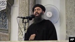 FILE - This image from video posted in July purports to show Islamic State leader Abu Bakr al-Baghdadi delivering a sermon in Iraq; he's said to have been wounded with British national "Jihadi John" in an airstrike last Saturday. 
