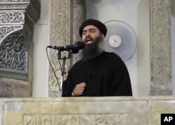 FILE - This image from video purports to show Islamic State leader Abu Bakr al-Baghdadi delivering a sermon in Iraq. Al-Baghdadi formally announced the formation of Islamic State of Iraq and Levant (ISIL) with Raqqa as its center in a recorded message in April of 2013.