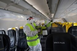 Airport personnel spray disinfectant as they sanitize a plane to prevent the spread of the coronavirus at Rome's Fiumicino airport, June 4, 2020.