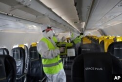 Airport personnel spray disinfectant as they sanitize a plane to prevent the spread of the coronavirus at Rome's Fiumicino airport, June 4, 2020.