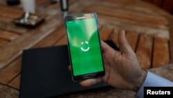 An employee shows the logo of ride-hailing company Careem on his mobile in his office in the West Bank city of Ramallah, July 17, 2017.