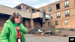 Judy Burton becomes emotional while standing outside her apartment building, which was severely damaged in Friday's tornados, in Mayfield, Ky., Sunday, Dec. 12, 2021. (AP Photo/Claire Galofaro)