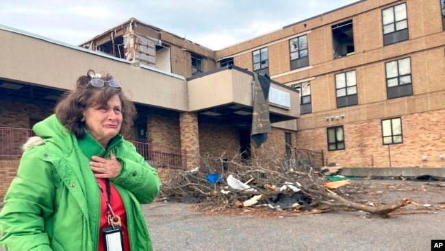 Judy Burton becomes emotional while standing outside her apartment building, which was severely damaged in Friday's tornados, in Mayfield, Ky., Sunday, Dec. 12, 2021. (AP Photo/Claire Galofaro)
