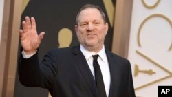 FILE - Harvey Weinstein arrives at the Oscars in Los Angeles, California, March 2, 2014. Weinstein has been fired from The Weinstein Co., effective immediately, following new information revealed regarding his conduct, the company's board of directors announced Oct. 8, 2017.