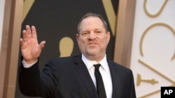 FILE - Harvey Weinstein arrives at the Oscars in Los Angeles, California, March 2, 2014. Weinstein has been fired from The Weinstein Co., effective immediately, following new information revealed regarding his conduct, the company's board of directors announced Sunday, Oct. 8, 2017.