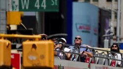 资料照片：人们不戴口罩，乘旅游车参观纽约市的时报广场。(2021年5月14日)