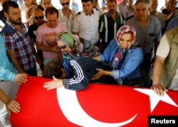 Relatives of Gulsen Bahadir, a victim of Tuesday's attack on Ataturk airport, mourn at her flag-draped coffin during her funeral ceremony in Istanbul, Turkey, June 29, 2016.