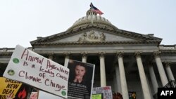 Posters are hoisted in front of the US Capitol as actresses and activists Lily Tomlin and Jane Fonda lead a climate protest in Washington, DC on December 27, 2019. 