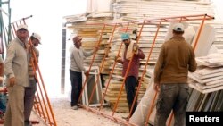 FILE - Syrian refugee workers prepare to recycle damaged tents at a workshop of the Norwegian Refugee Council at Al Zaatari refugee camp in the Jordanian city of Mafraq, near the border with Syria, Sept. 15, 2014.