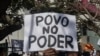 Um homem segura uma faixa com a inscrição “poder do povo” durante a reunião que antecede a marcha convocada por membros da comunidade islâmica moçambicana contra os resultados das eleições presidenciais de 2024, em Maputo, a 2 de novembro de 2024.