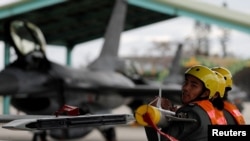 FILE PHOTO: Air force crews lift an AIM-9 Sidewinder air-to-air missiles to be loaded onto Northrop F-5 fighter during a military drill at Zhi-Hang Air Base in Taitung
