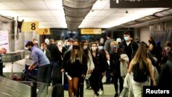 Para penumpang mengenakan masker di bandara Denver, Colorado, AS (foto: ilustrasi). 