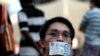 A man covers his mouth with a fifty dollar bill represent the lost of free speech at the Speakers Corner on Saturday, June 8, 2013 in Singapore to protest a new government policy that requires news websites to obtain licenses. The policy that came…