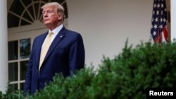 El presidente estadounidense Donald Trump en el Jardín Rosado de la Casa Blanca escucha al fiscal Bill Barr sobre esfuerzos de su administración por el Censo 2020. Julio 11 de 2019. Reuters.