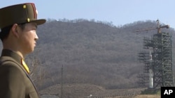 A crowd of media gather around a North Korean official in front of North Korea's Unha-3 rocket, slated for liftoff between April 12-16, at Sohae Satellite Station in Tongchang-ri, North Korea, April 8, 2012.