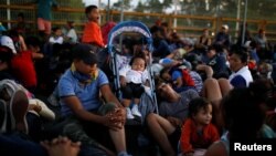 Migrants, part of a caravan travelling to the U.S., gather near the border between Guatemala and Mexico, in Tecun Uman, Guatemala, Jan. 20, 2020.