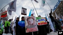 FILE - Demonstrators hold posters reading "There is no place for juvenile justice in Russia," "I want all children be happy" during a massive rally in Moscow, March 2, 2013. 