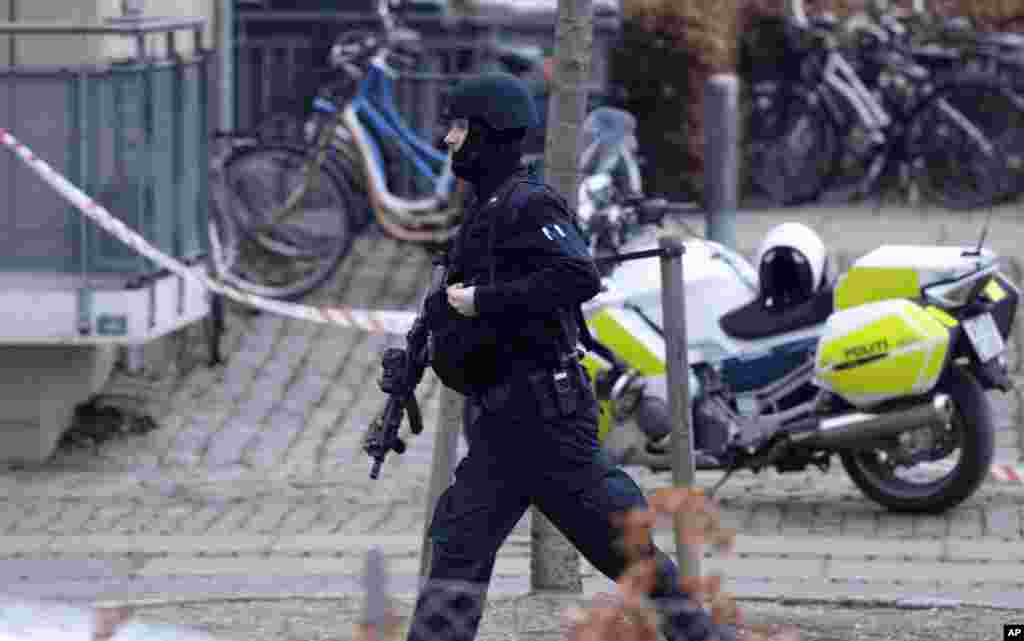Nhân viên an ninh vũ trang chạy xuống một con phố gần địa điểm vụ nổ súng tại Copenhagen, ngày 14/2/2015.