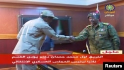 FILE - Lt. Gen. Abdel Fattah al-Burhan, right, shakes hands with Sudan's General Abdelfattah Mohamed Hamdan Dagalo in Khartoum, Sudan, April 13, 2019 in this still image taken from video.