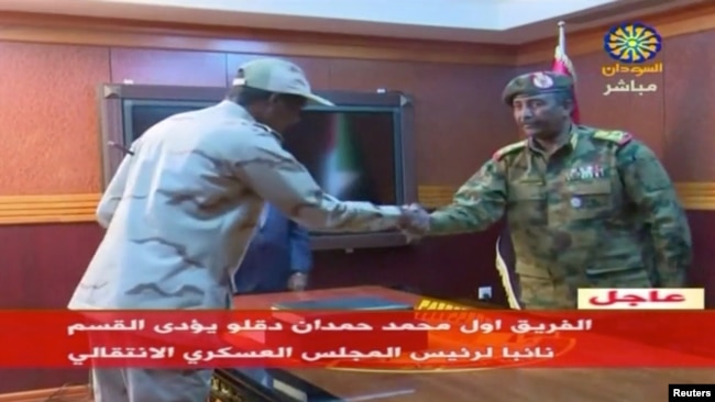 FILE - Lt. Gen. Abdel Fattah al-Burhan, right, shakes hands with Sudan's General Abdelfattah Mohamed Hamdan Dagalo in Khartoum, Sudan, April 13, 2019 in this still image taken from video.