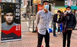 12港人关注组成员、本土派社运人士邹家成（左）与荃湾区议员岑敖晖，12月19日在大围港铁站外摆街站。 (美国之音/汤惠芸)