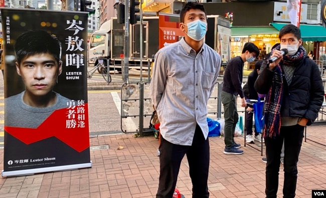 12港人关注组成员、本土派社运人士邹家成（左）与荃湾区议员岑敖晖，12月19日在大围港铁站外摆街站。 (美国之音/汤惠芸)