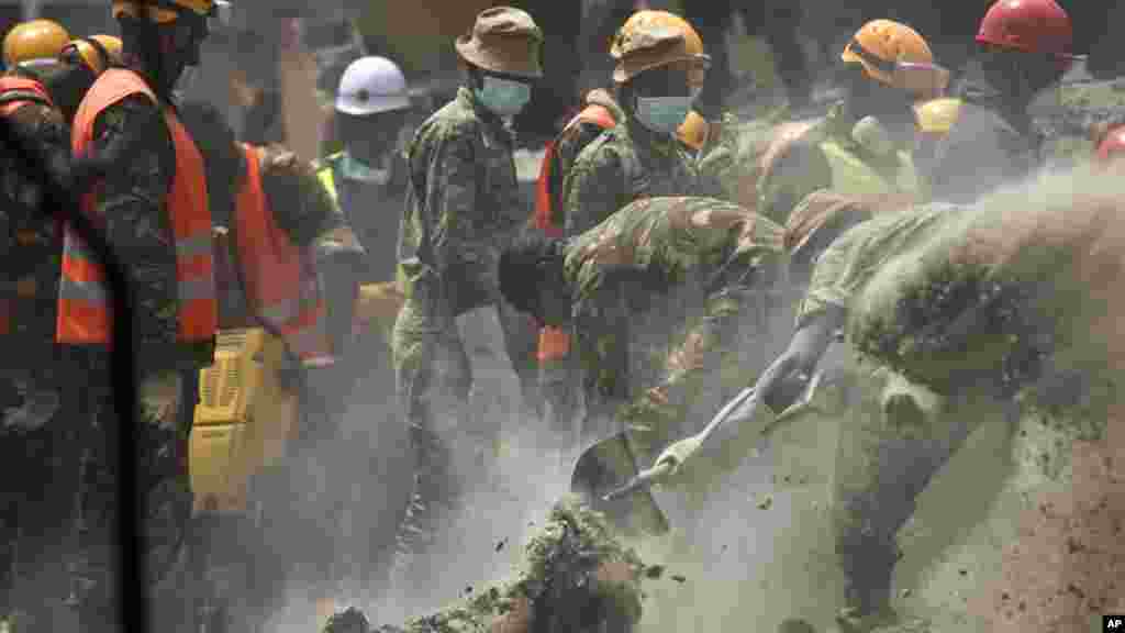 Les secouriste essaient de libérer une femme qui a été emprisonnée pendant six jours dans les décombres d&#39;un bâtiment effondré, dans la zone Huruma de Nairobi, au Kenya le 5 mai 2016.