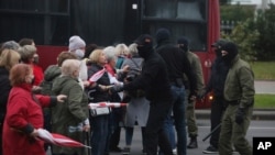 Para pengunjuk rasa, yang kebanyakan perempuan lansia, beradu mulut dengan para polisi berbaju preman dalam demo menentang hasil pilpres di Minsk, Belarus, 12 Oktober 2020.