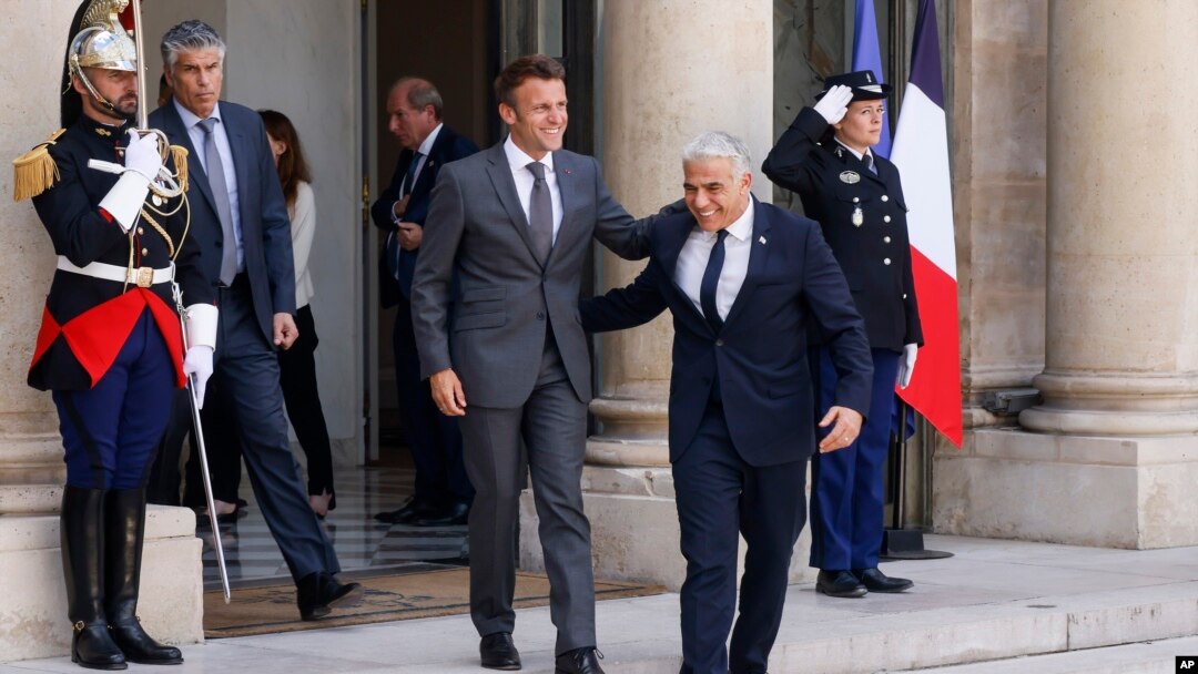 Presiden Prancis Emmanuel Macron (tengah, kiri) dan Perdana Menteri Israel Yair Lapid menuruni anak tangga untuk bertemu awak media setelah melangsungkan pertemuan di Istana Elysee di Paris, pada 5 Juli 2022. (Foto: AP/Thomas Padilla)
