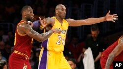 Kobe Bryant (No. 24, an jonn sitwon) tap tann yon pas pandan yon lòt gwo vedèt NBA a, LeBron James, tap make li nan yon match ki tap dewoule nan Los Angeles nan dat 10 mas 2016 la. (Foto: Danny Moloshok/AP).