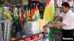 FILE - A Kurdish man sells flags of the semi-autonomous region of Kurdistan in his shop in Arbil, 310 km (193 miles) north of Baghdad, Aug. 30, 2009.