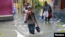 Residents carry their belongings as they evacuate their house after flooding caused by Cyclone Ockhi in the coastal village of Chellanam in the southern state of Kerala, India, Dec. 2, 2017. 