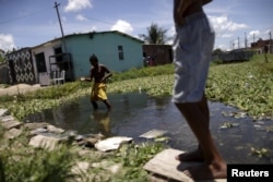 Children play in water at a slum in Recife, Brazil, March 2, 2016.