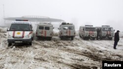 Kendaraan dan ambulans disiagakan di dekat lokasi jatuhnya pesawat penumpang dekat kota Almaty, Kazakhstan hari Selasa (29/1).
