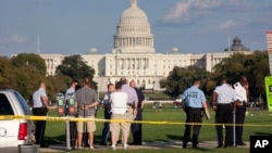 Law enforcement officers are near the scene on the National Mall in Washington, where, according to a fire official, a man set himself on fire, Oct. 4, 2013.