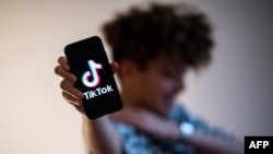 FILE: A teenager presents a smartphone with the logo of Chinese social network Tik Tok, on 1.21.2021 in Nantes, western France