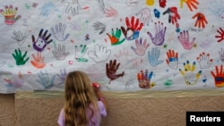 Cali Wilson, 7, draws a rainbow on a poster at the office of U.S. Rep. Gabrielle Giffords in Tucson, Arizona, Jan. 16, 2011.