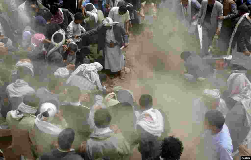 Mourners bury the body of Bashar Arhab, a victim of one of Friday's suicide bombings at mosques, in a grave in Sanaa, March 23, 2015.