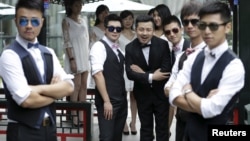 Ling Jueding (C) poses for a photo with his best men before his wedding ceremony at a park in Beijing, June 2015. (REUTERS)