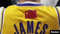资料照片：NBA超级明星勒布朗·詹姆斯的中国球迷身穿有他名字的背心观看洛杉矶湖人队和布鲁克林篮网队在上海的比赛。（2019年10月10日）