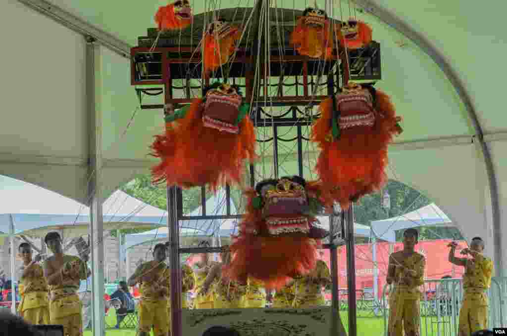 Performers pull strings for their show at the Smithsonian Folklife Festival in Washington, June 25, 2014. (Regina Catipon/VOA)